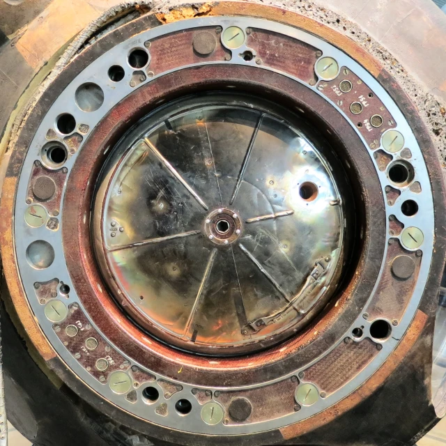 the inside of an old, rusty clock, seen from below
