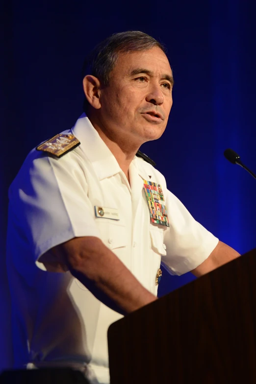 a man in uniform stands at a podium and gives a speech