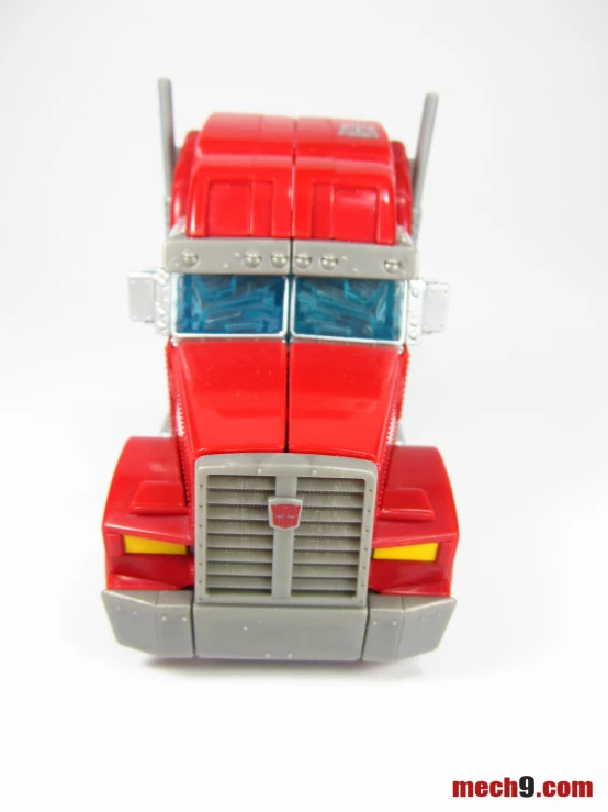 a small plastic toy truck with a red body