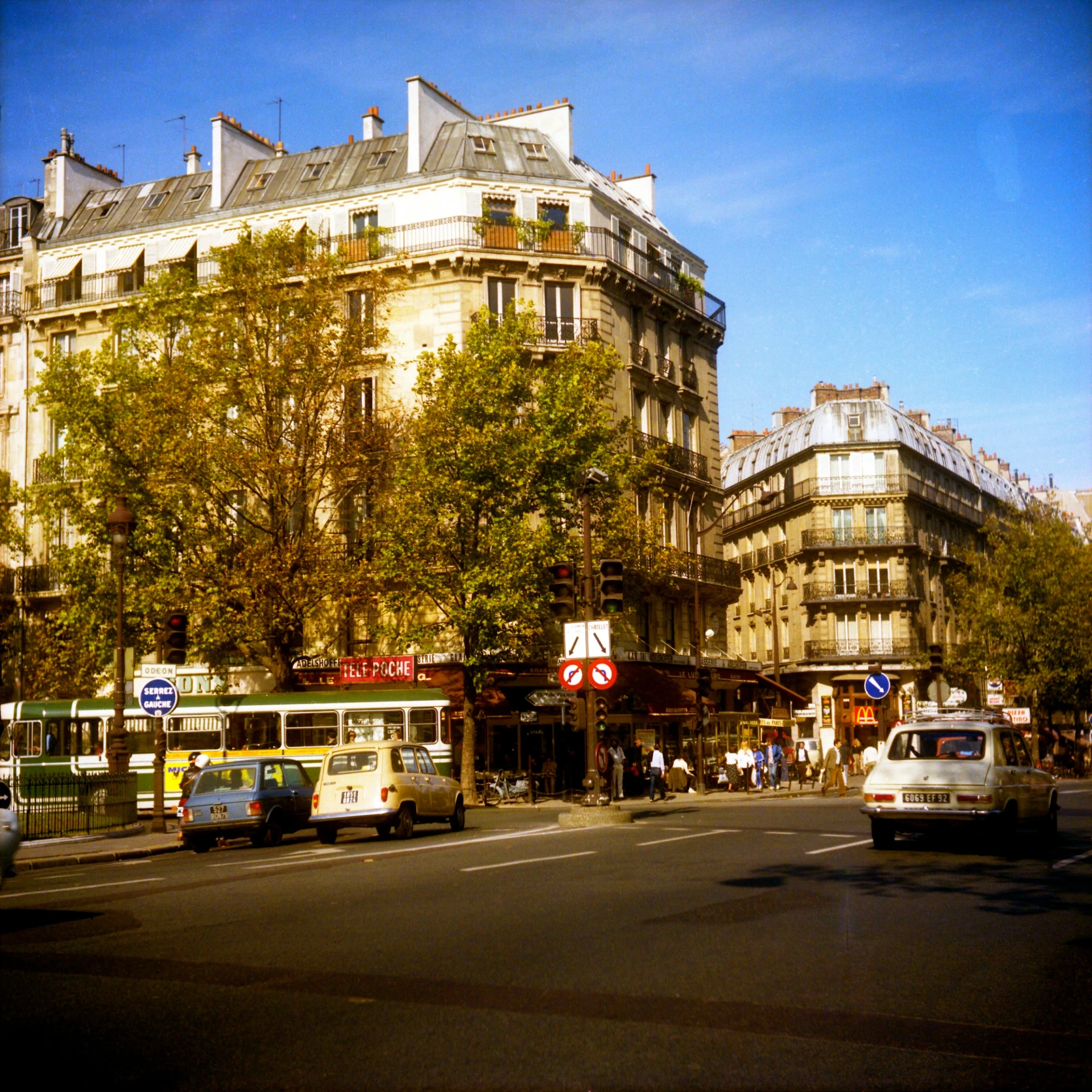 vehicles and people sit along a busy street