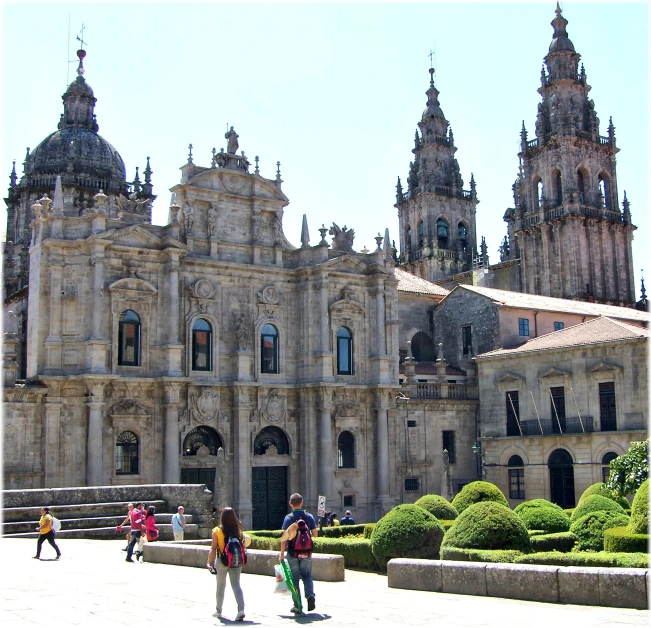 a group of people walking across a stone plaza in front of a large building