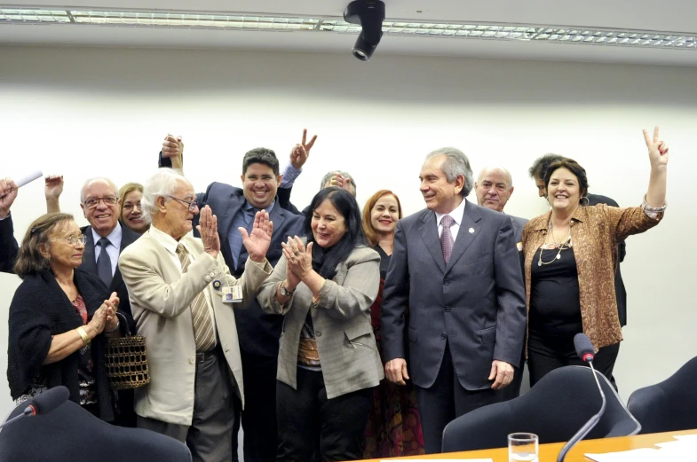 a group of people applauding as one of them claps his hands