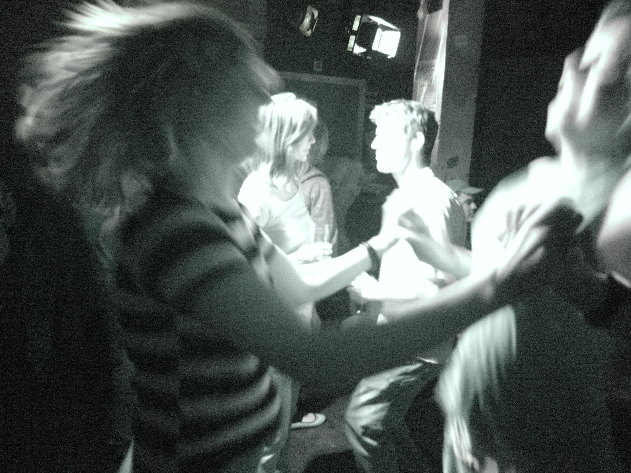 four people standing in a room with dark lighting