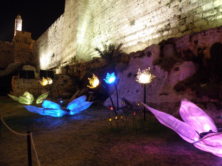 there are many lit up umbrellas outside on the ground