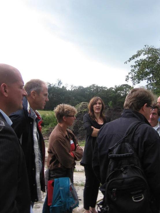 people on the sidewalk looking at a giraffe