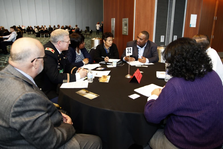 a group of people sit at a table with signs