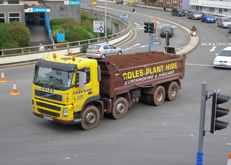 a yellow dump truck traveling down the road