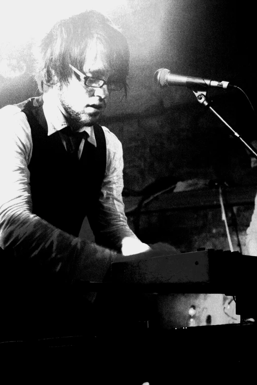 the young man is playing piano on stage