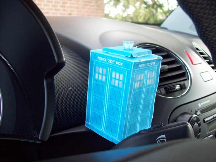 a plastic blue box sitting on top of a car dashboard