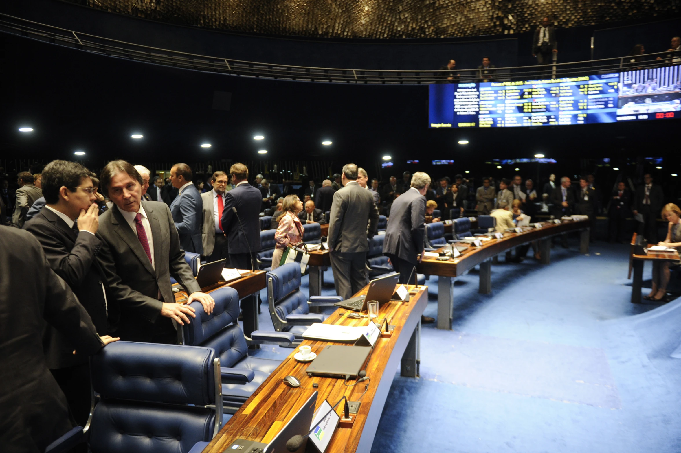 people in a room with blue chairs and tables