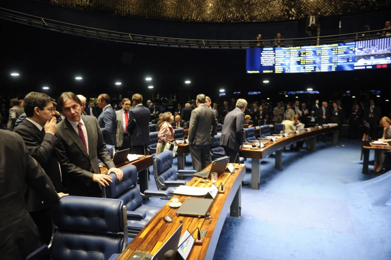 people in a room with blue chairs and tables