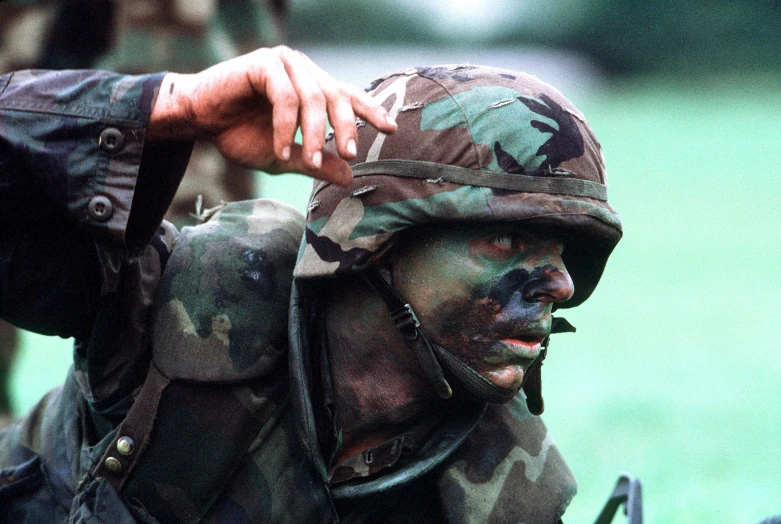 a man in camouflage uniform holding a bag