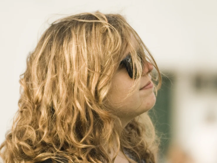 a blonde haired woman wearing sunglasses looking off to the side