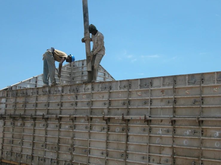 two men are working on soing that is being built