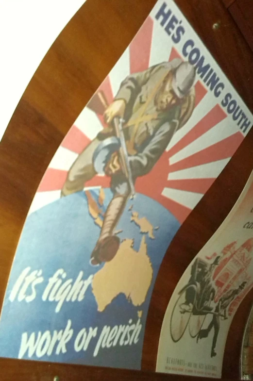 two vintage posters hanging on the wall above a clock
