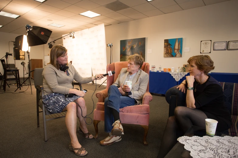 a woman sitting next to two other people