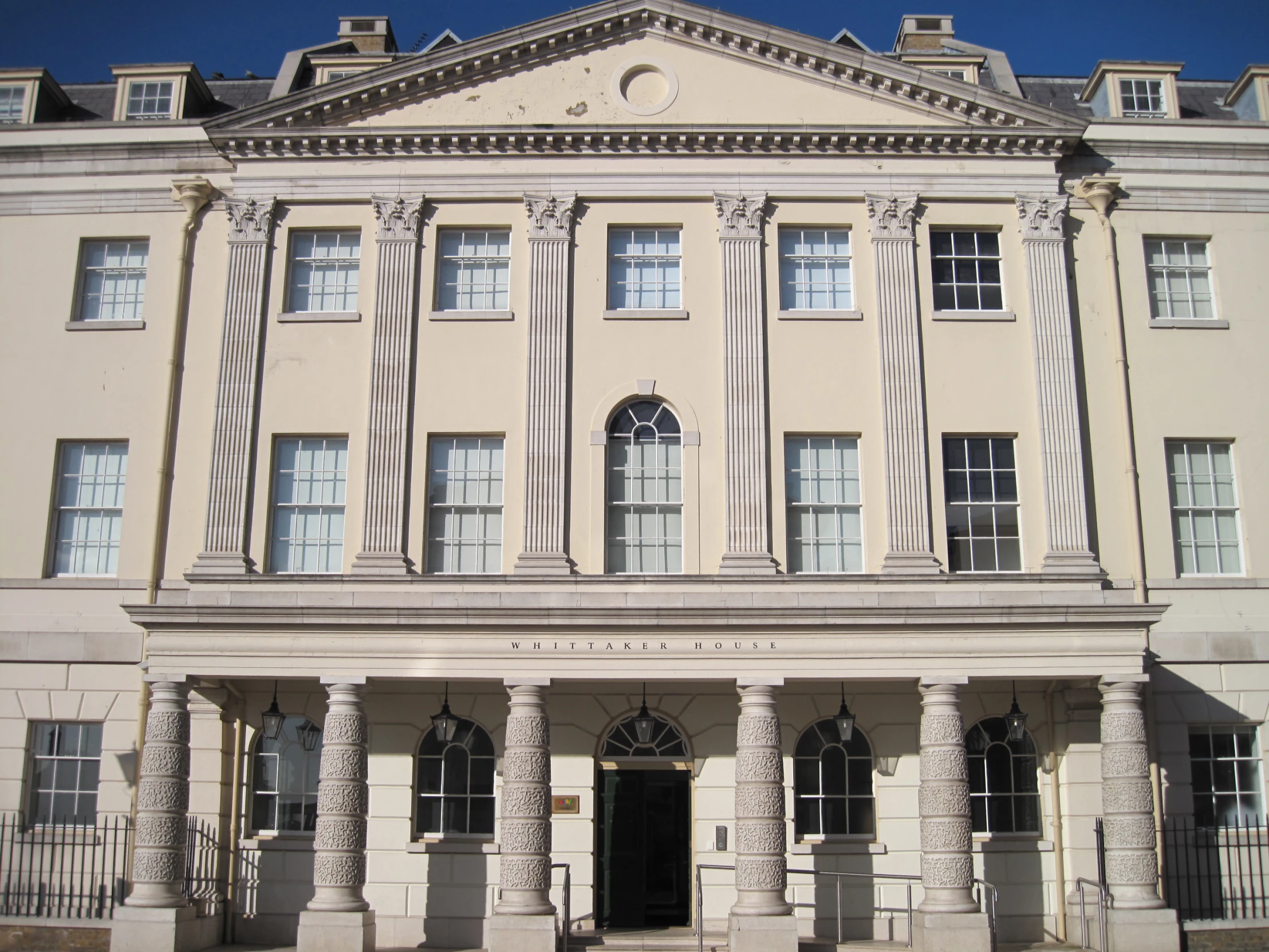 a large white building with a clock in the middle