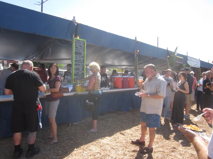 group of people having conversation near a food stand