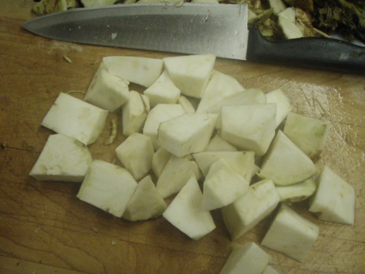 the sliced up white potatoes are sitting next to a knife