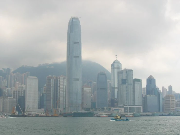 a boat in a body of water near some tall buildings