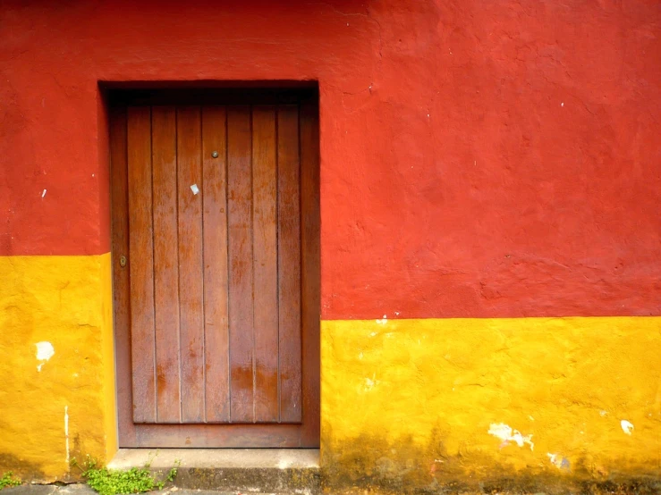 an open wood door between two red and yellow walls