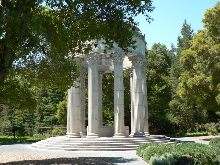 an outdoor well with stone columns on the side of it