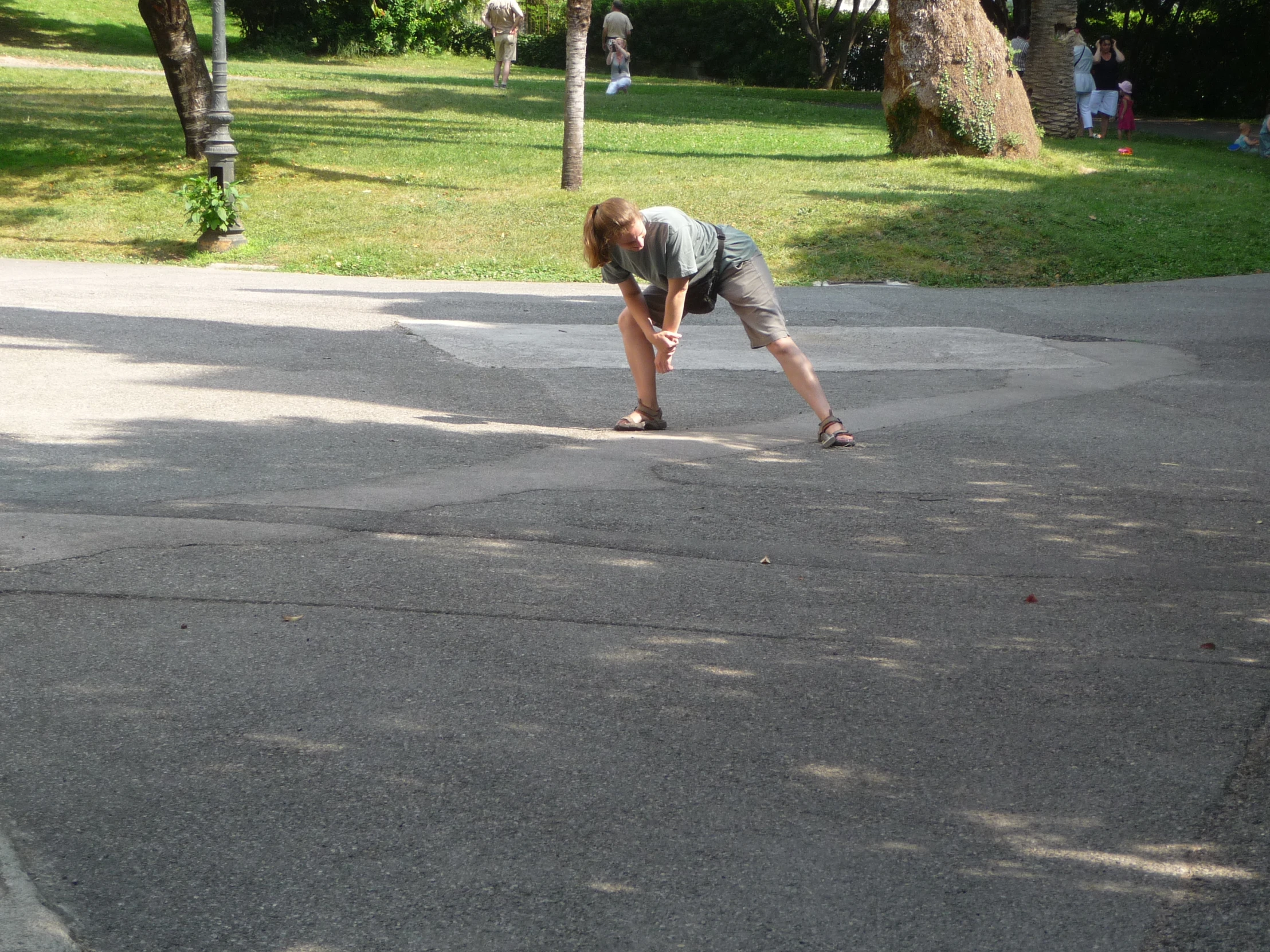 a woman crouched down on her knees while she holds onto her skateboard