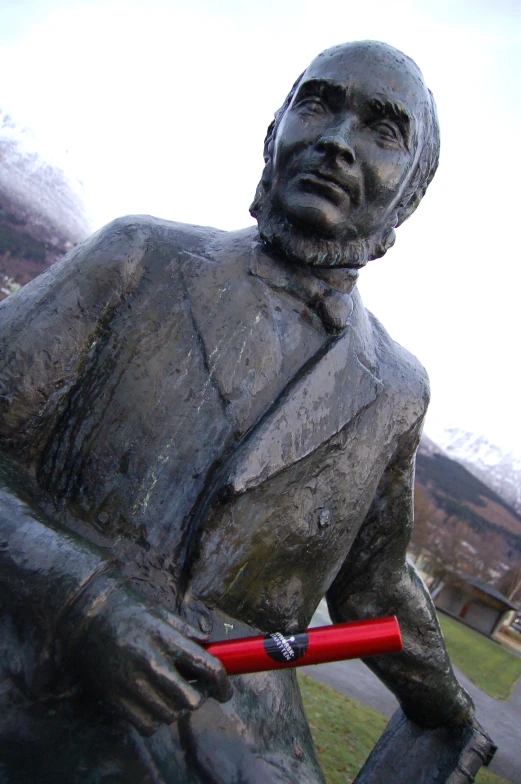 a statue holding a baseball bat near a park