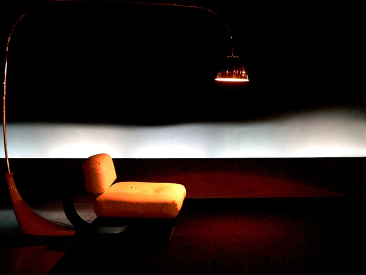 an orange chair with black back and dark background