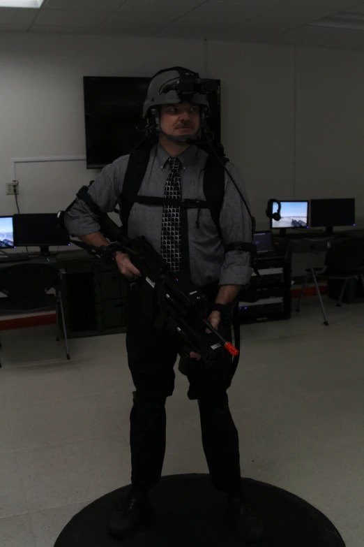 a man holding a rifle on a black ball with a back pack