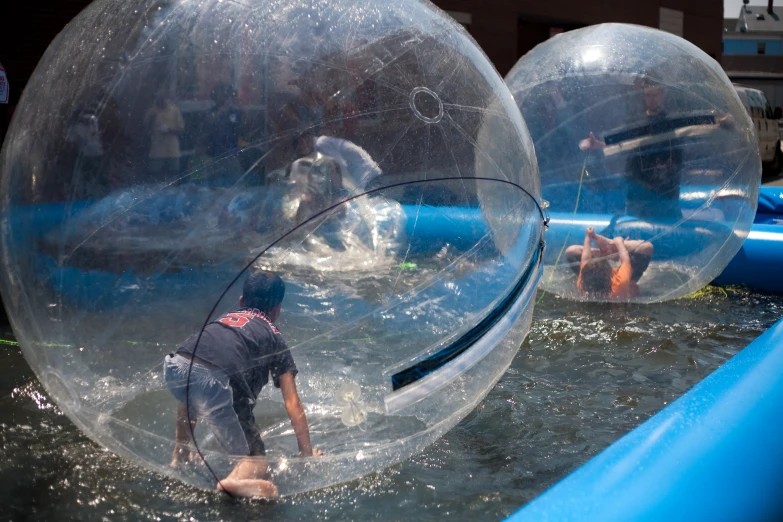 two people are riding inside a water ball