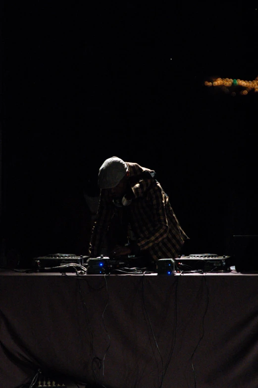 a man is bending down on some electronic equipment