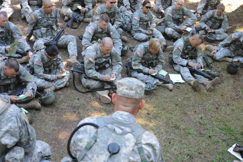 some soldiers are sitting in the grass together