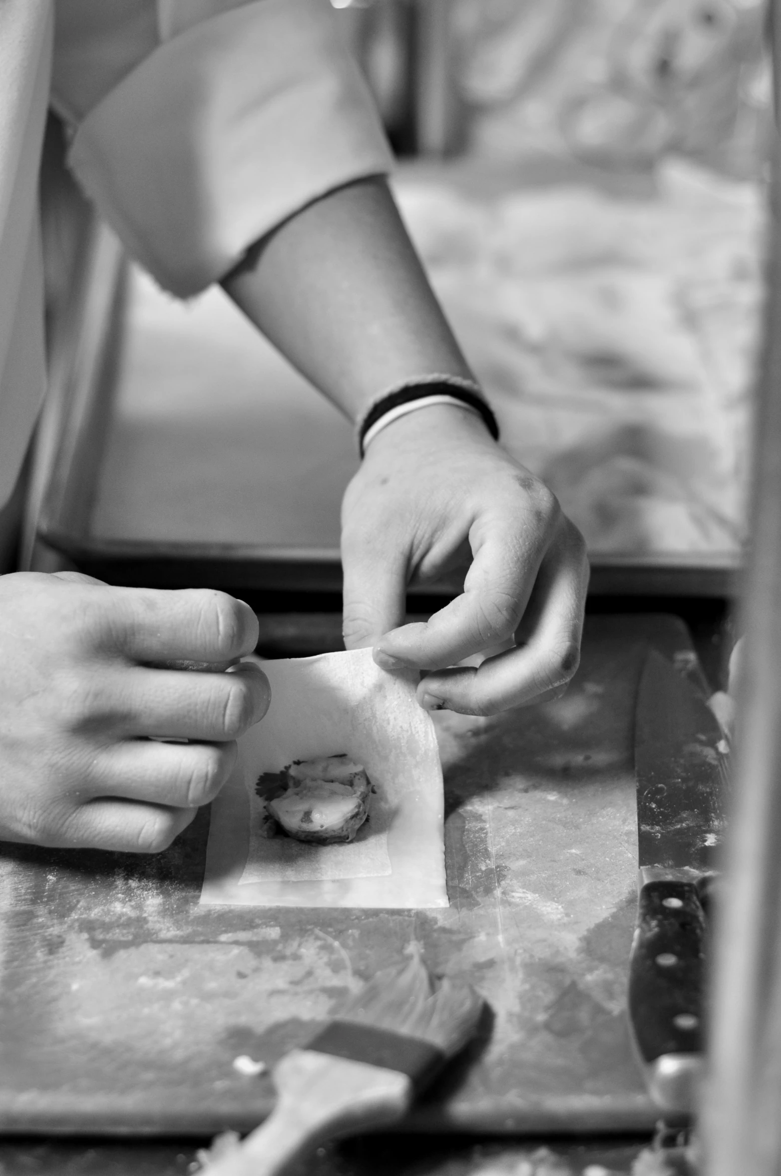 two hands holding small objects on a table