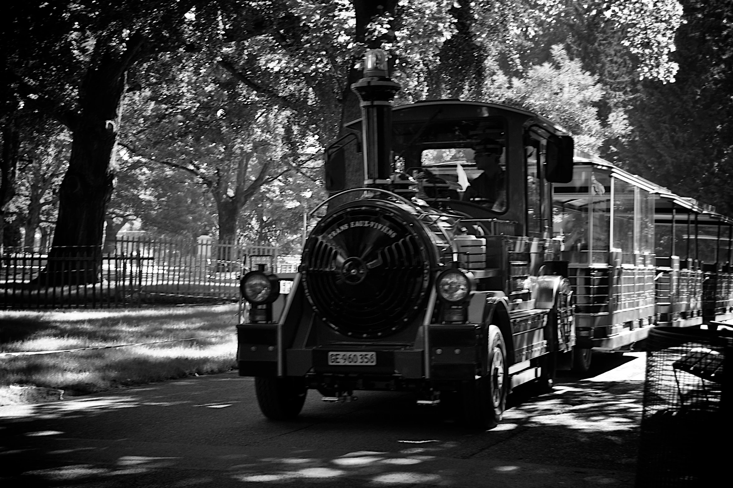 an old style steam engine driving in a park