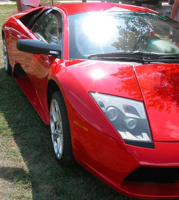 a red sports car is parked on grass