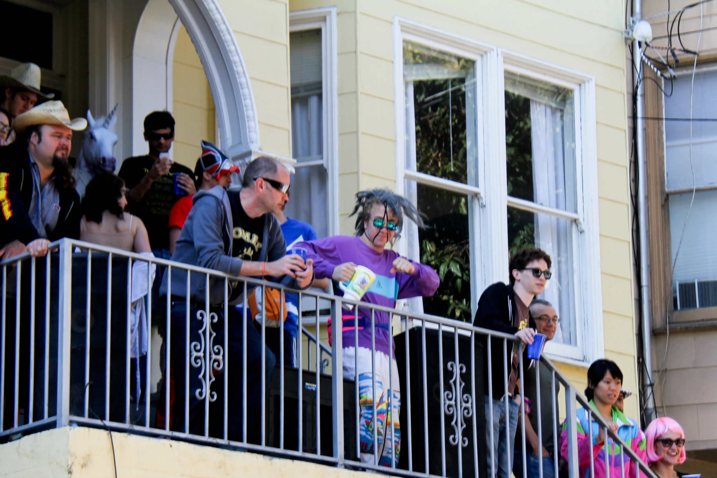 people watch soing from an outdoor balcony overlooking buildings