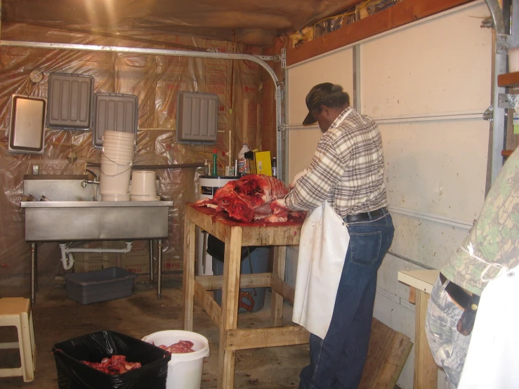 a person working in a kitchen next to garbage