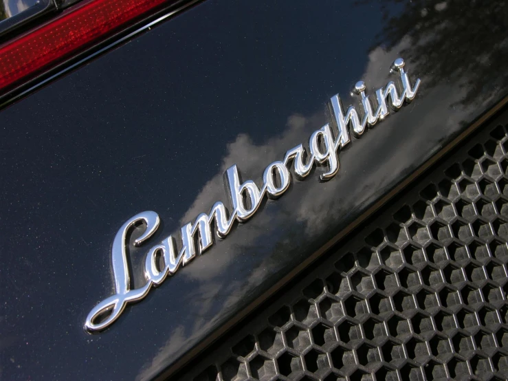 a name on the back of a car that is parked in front of a tree