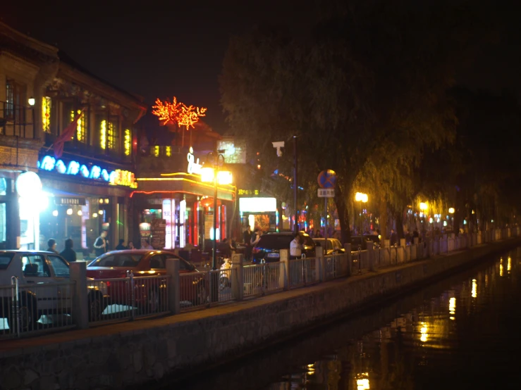 the city street has people walking on it at night