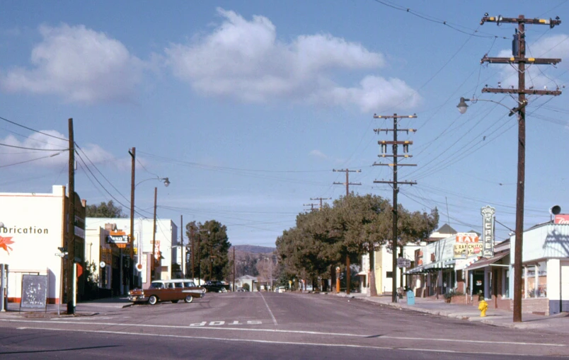 a empty road with businesses and telephone poles