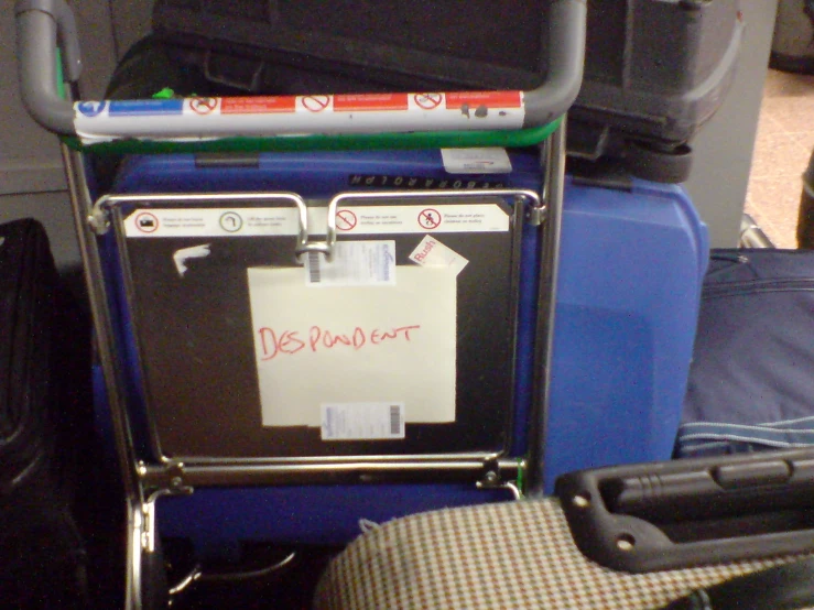 a suitcase and a luggage cart with notes attached to it