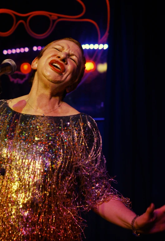 a woman in a silver dress performing a music event