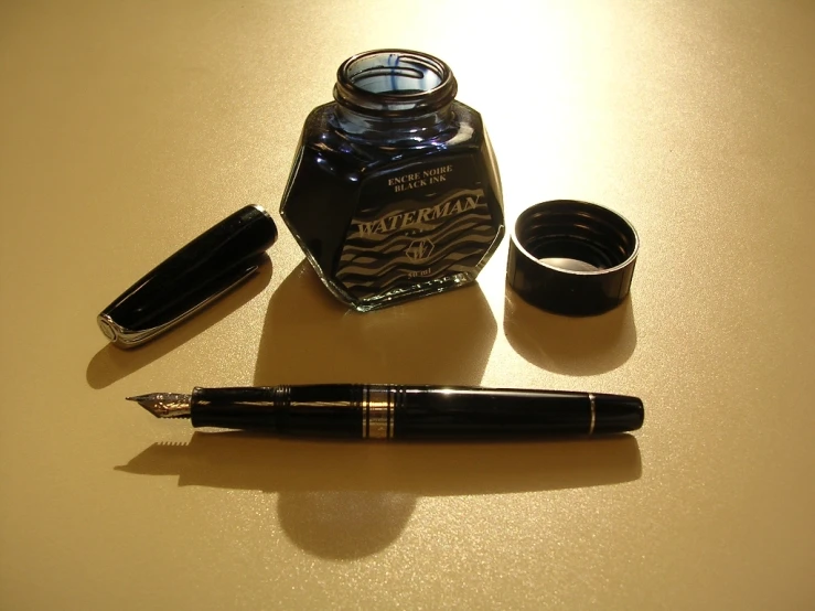 fountain pens and ink on top of a table