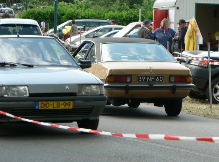 cars parked and people onlooking in background