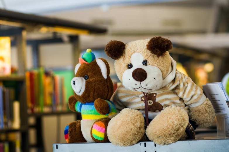 stuffed animals in the shape of bears sitting on top of a book