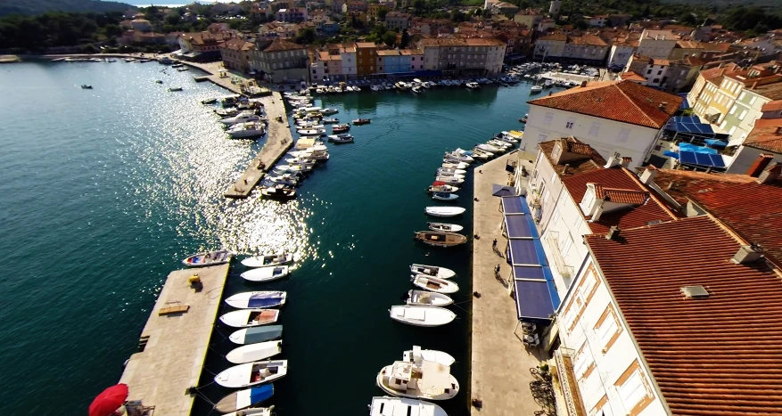 boats are parked along the dock next to a row of buildings