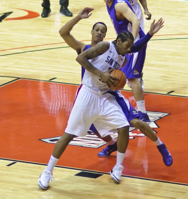 the basketball players are fighting for the ball during the game