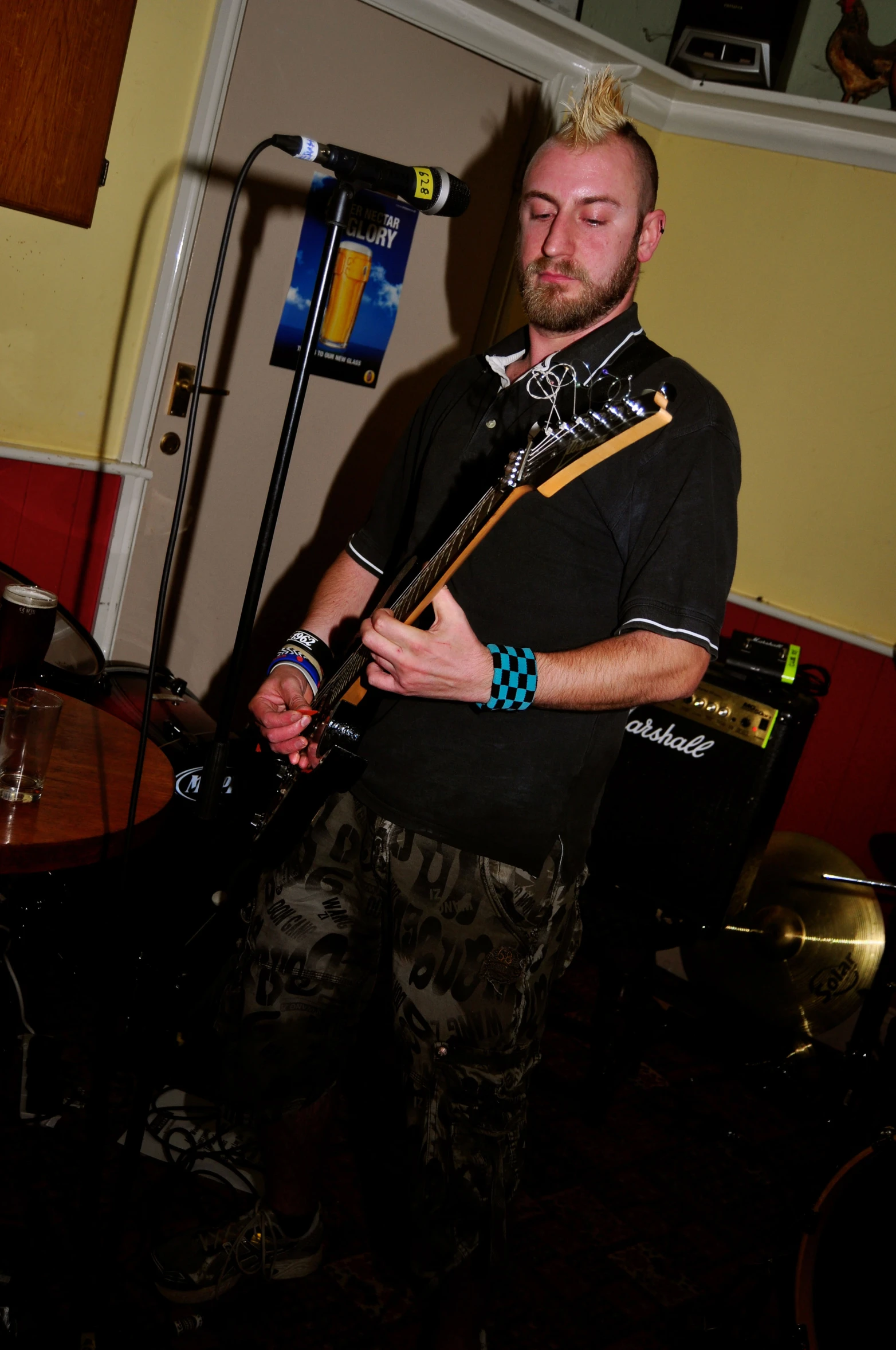 a male with a black shirt playing guitar