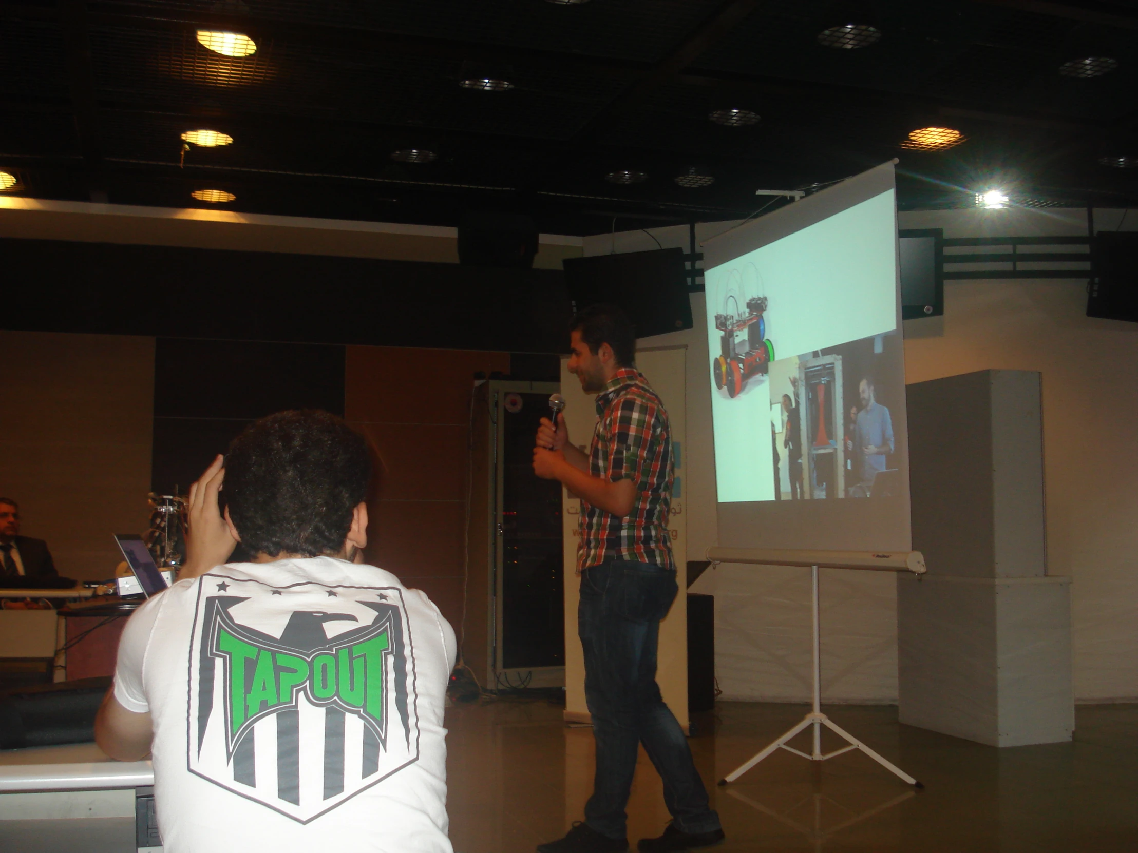 man standing in front of projector screen giving a presentation